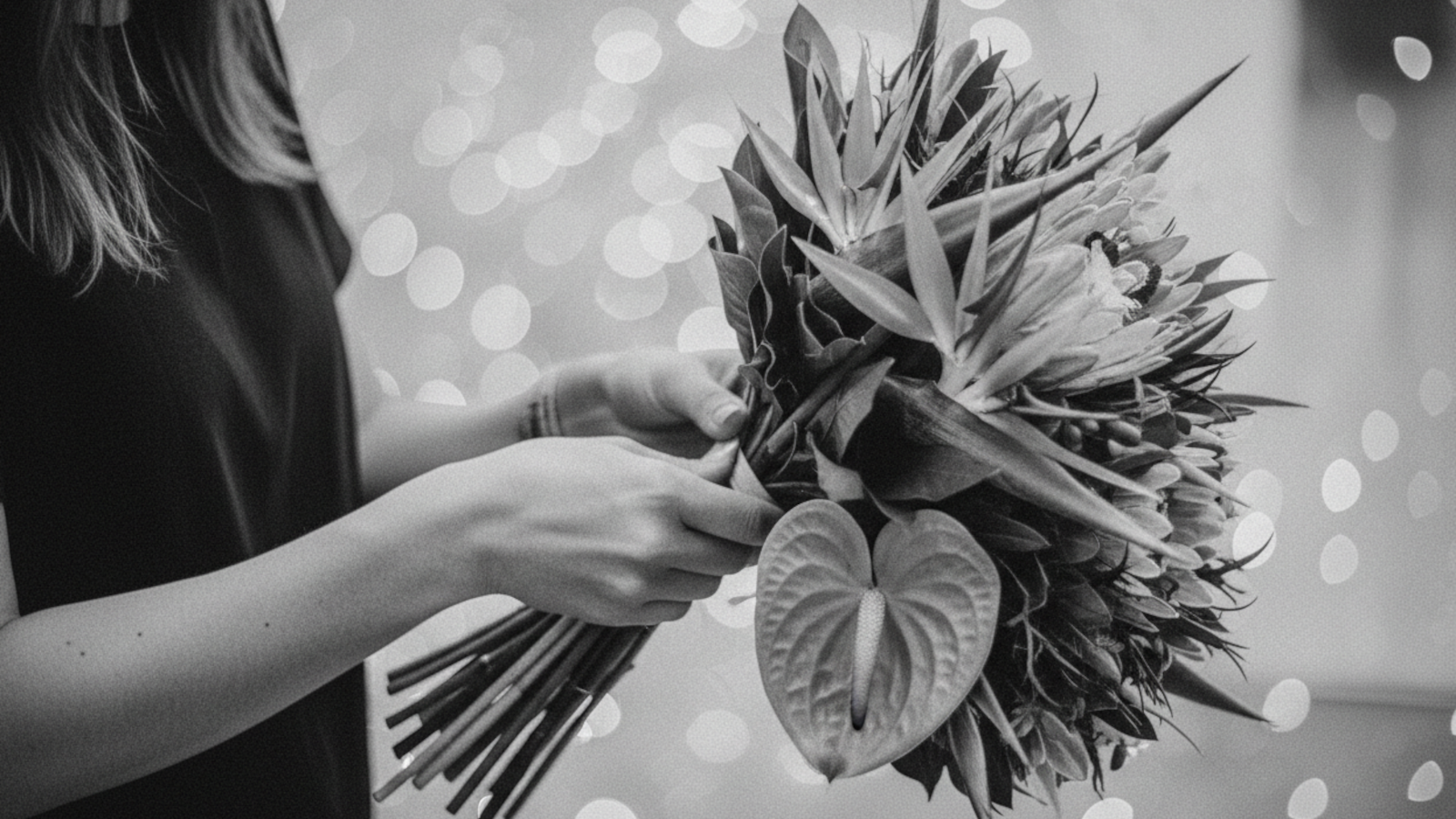 Person holding a bouquet of flowers with a blurred light background